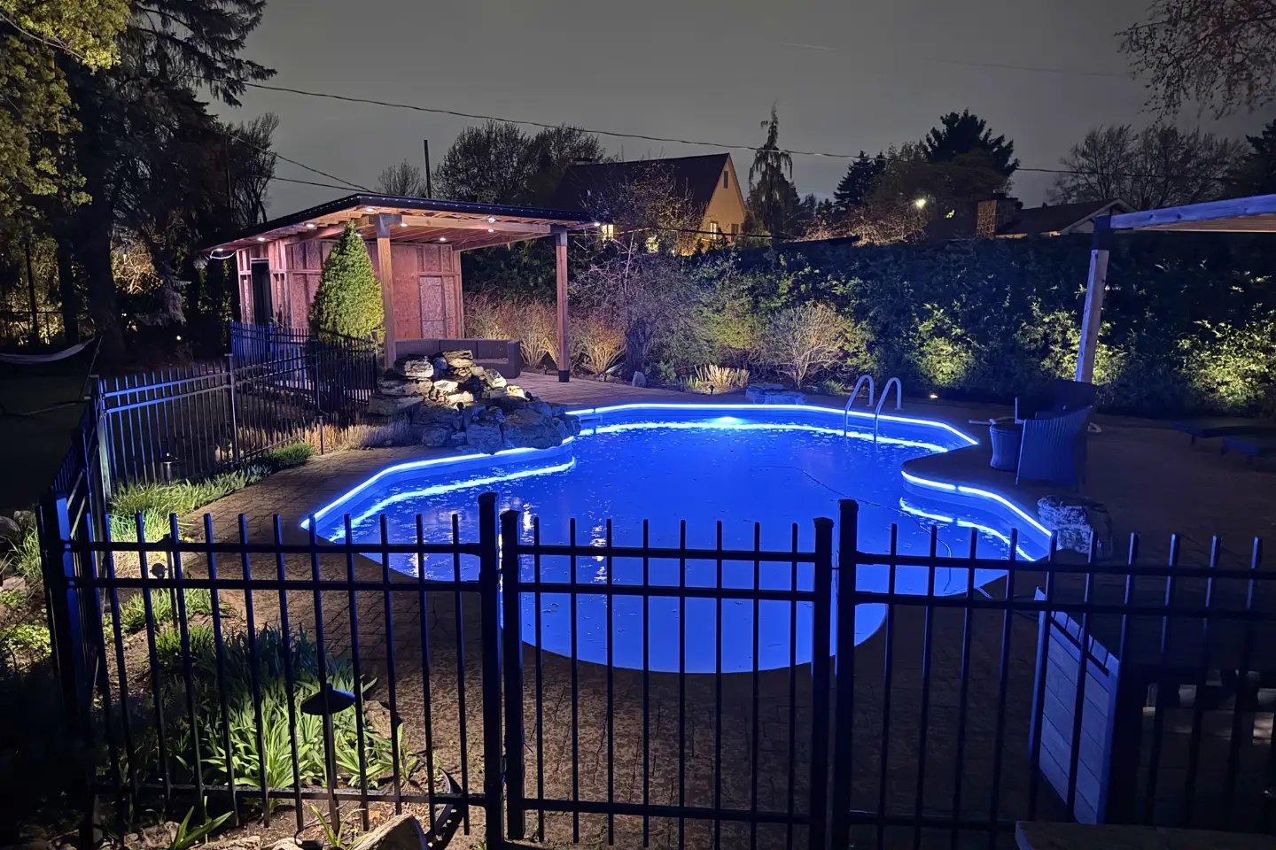 Piscine creusée éclairée en bleu, spots dans les plates-bandes